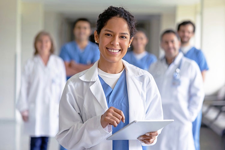 Doctor stands in front of another group of doctors